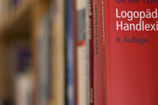Bücherregal seitliche Perspektive, im Vordergrund Buch mit dem Titel Handlexikon Logopädie